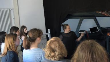 Das Bild zeigt Schülerinnen der Klassenstufe 10 im Flugsimulator der Fakultät Verkehrswissenschaften