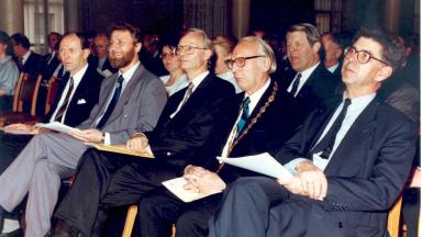 Men in suits siting in a row.