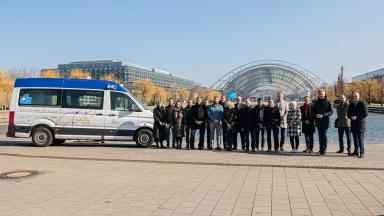 A group of people stand outside next to a van