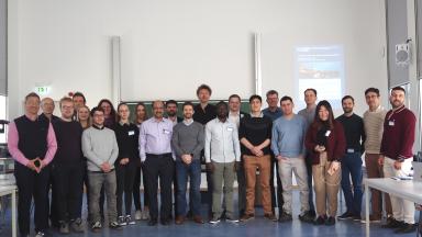 Ein Gruppenbild mit ca. 30 Personen in einem Seminarraum vor einer Tafel