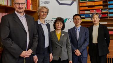 Zwei Männer und Drei Frauen vor dem Banner der Fakultät Verkehrswissenschaften