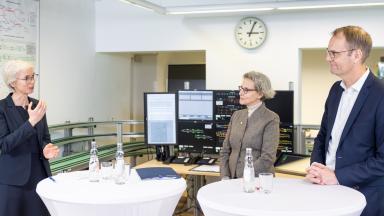 Two women and a man standing in a laboratory
