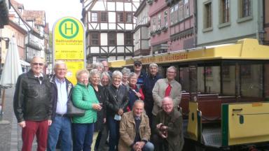 People in a street at a bus stop