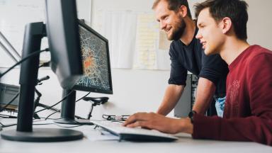 Two men looking at a computer screen