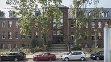 A brick building of the TU Dresden, below right a portrait of a man