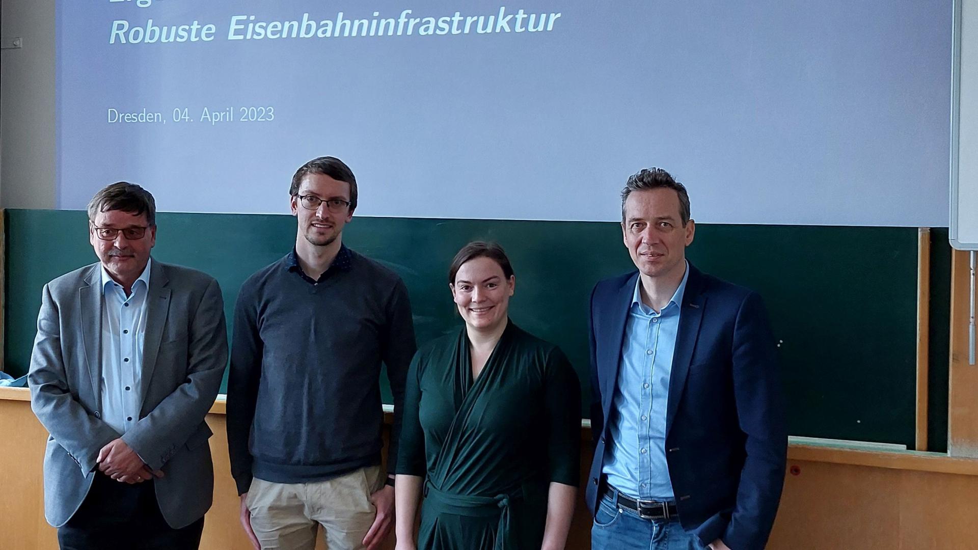 4 People standing in front of a board