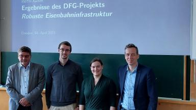 4 People standing in front of a board