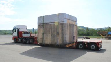 A truck with a large wooden box on the trailer