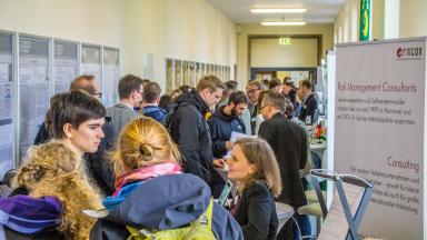 A corridor with exhibition stands and many people