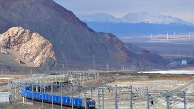 Güterzug fährt durch eine kahle Landschaft