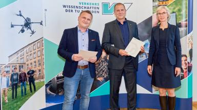 3 Menschen vor einer Fotowand