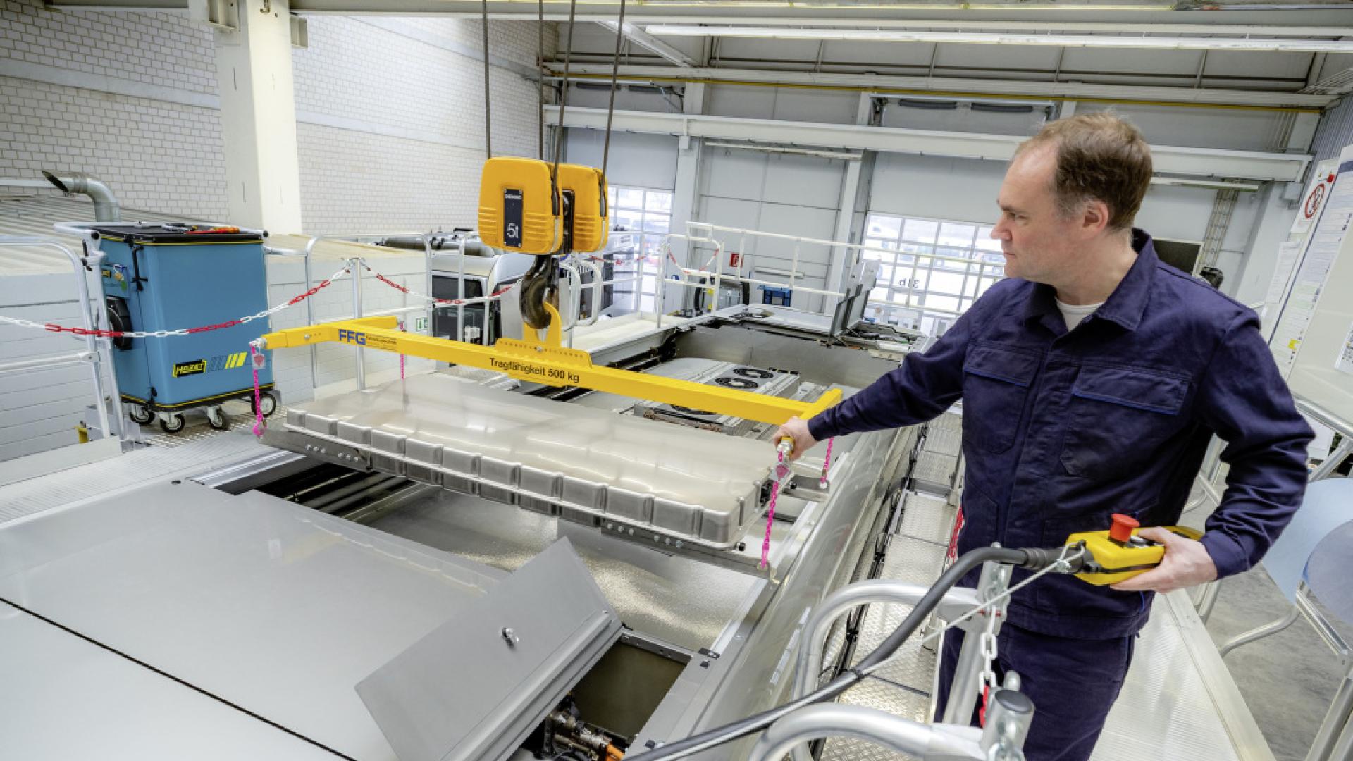 A man in a laboratory with car batteries.