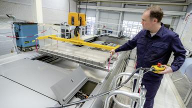 A man in a laboratory with car batteries.