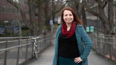 portrait from a woman in a winter coat and a red scarf.