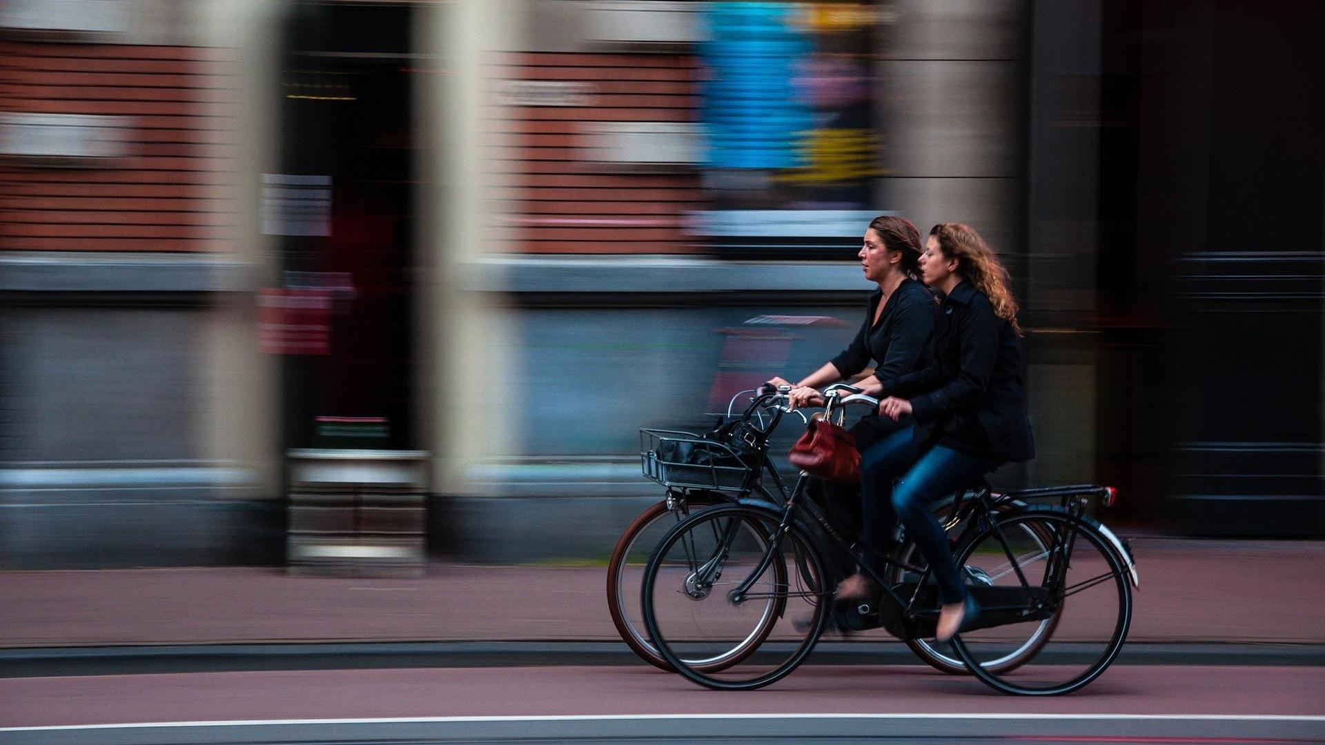 Two women cycling next to each other.