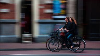 Two women cycling next to each other.