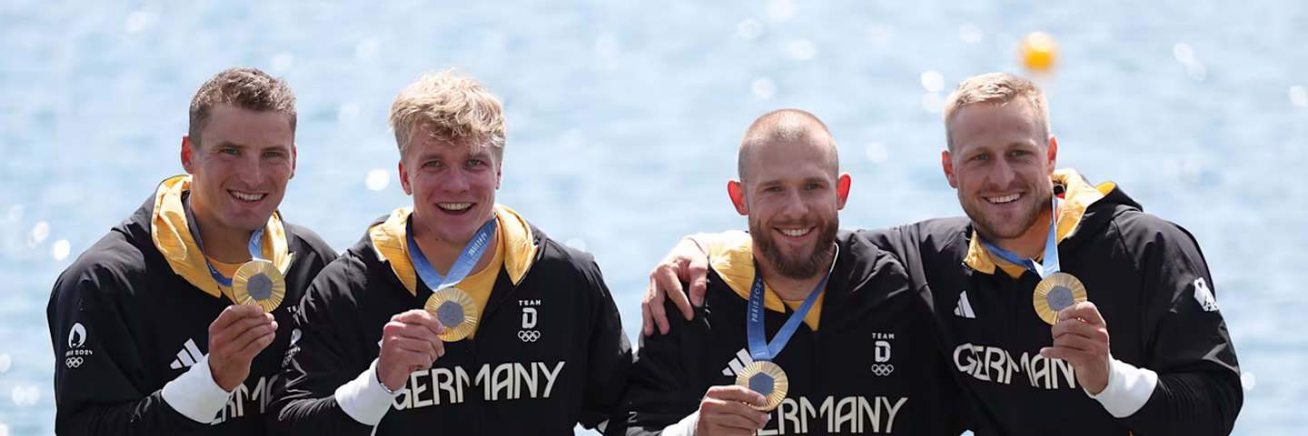 Das Bild zeit die deutsche Mannschaft im Kanu 4er mit olympischem Gold