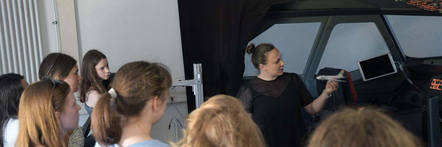 Das Bild zeigt Schülerinnen der Klassenstufe 10 im Flugsimulator der Fakultät Verkehrswissenschaften