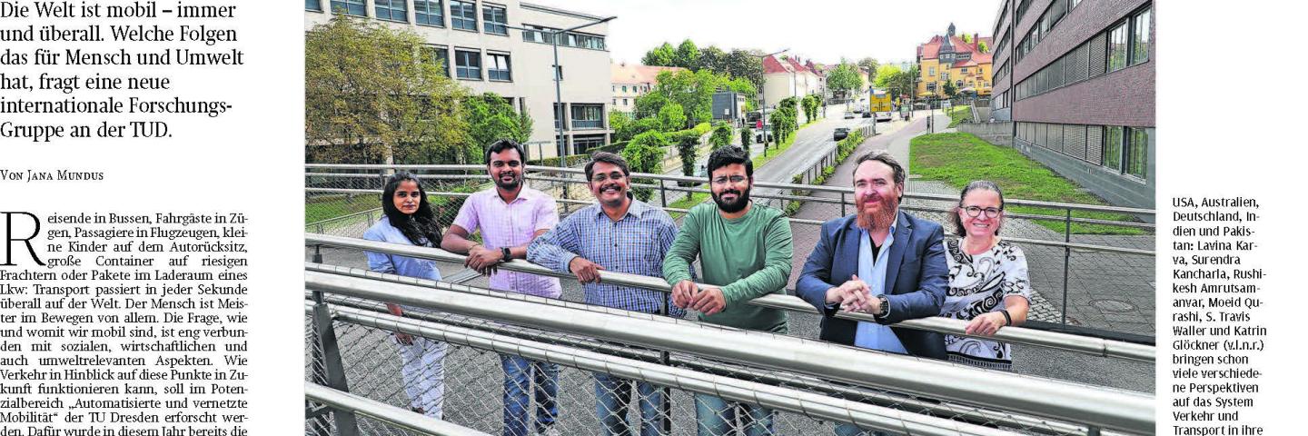 People stand on a bridge, a road leads underneath it