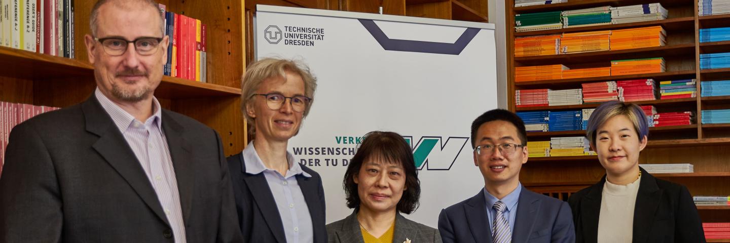 Zwei Männer und Drei Frauen vor dem Banner der Fakultät Verkehrswissenschaften