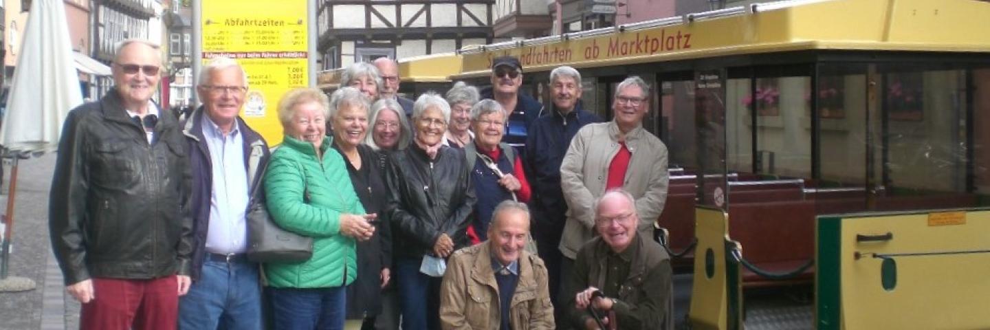 People in a street at a bus stop
