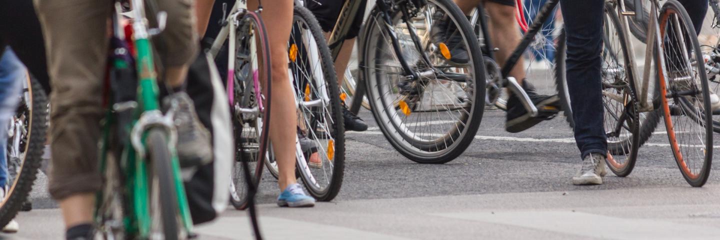 Serveral bycicles with people next to eachother