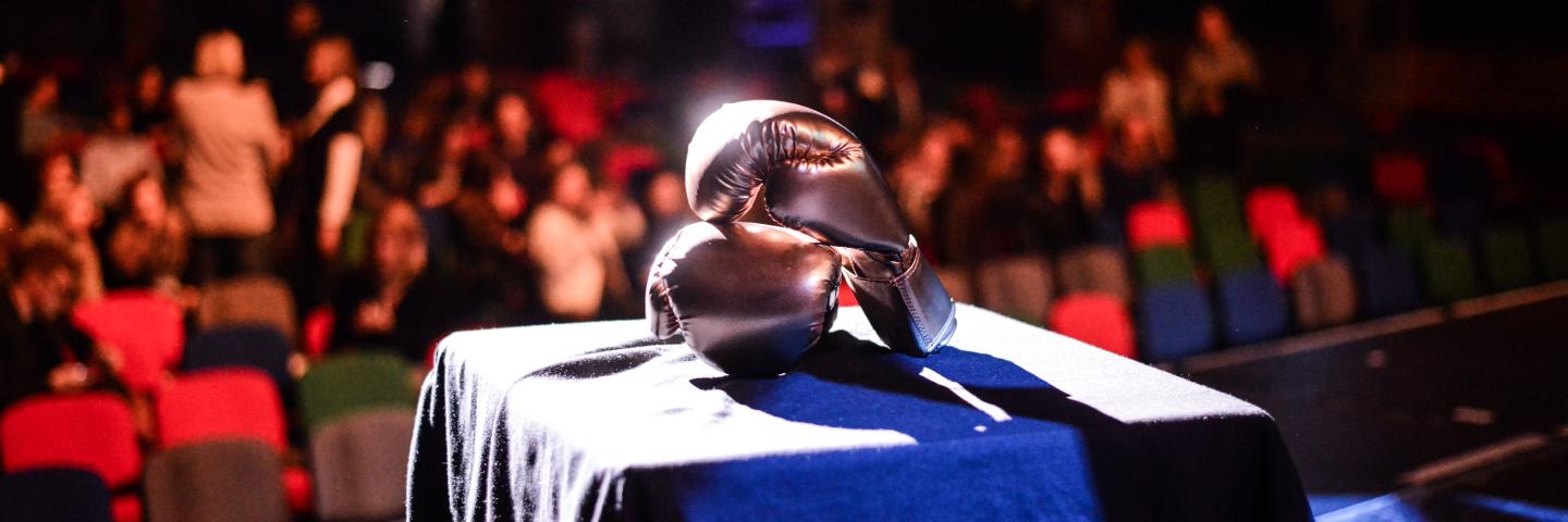 A stage with a table and boxing gloves on it