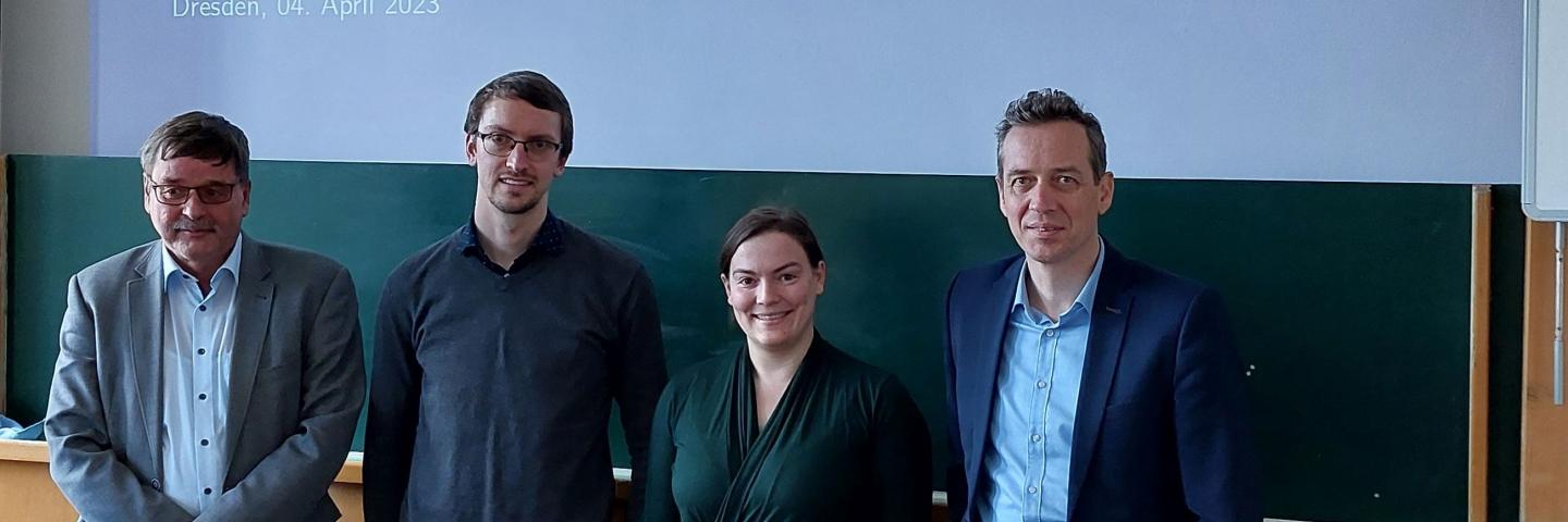 4 People standing in front of a board