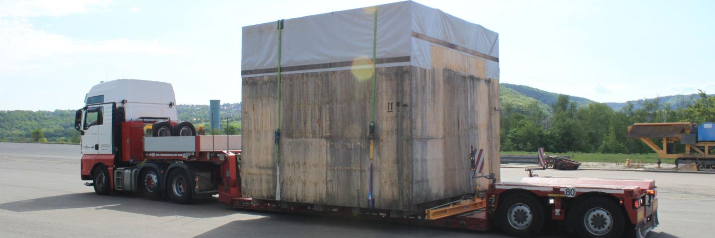 A truck with a large wooden box on the trailer