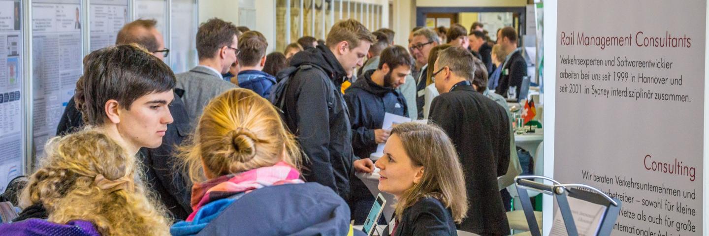 A corridor with exhibition stands and many people