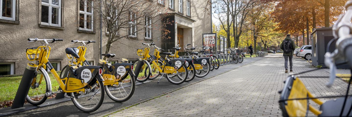 Exterior view of a TUD building with yellow rental bikes in front of it.
