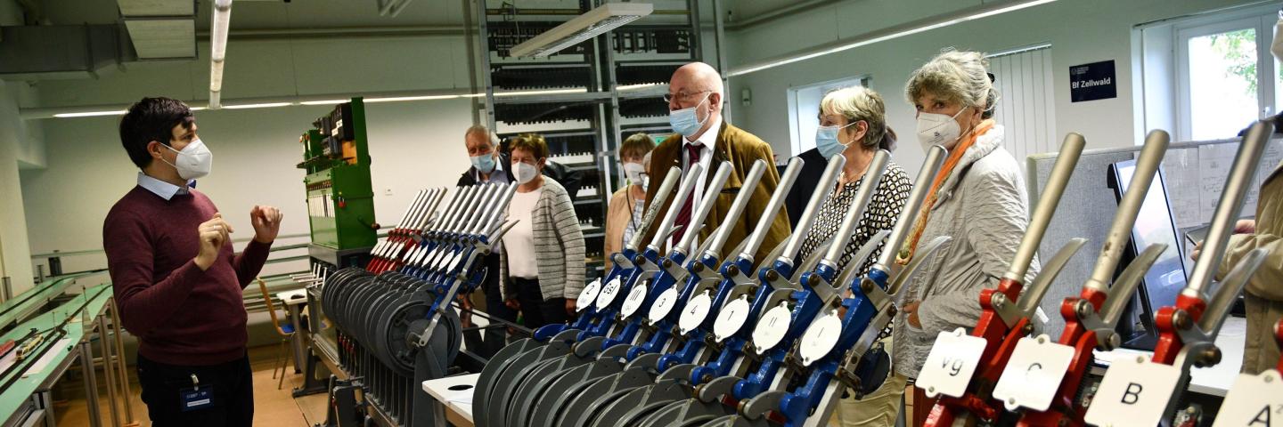 Personen in einem Eisenbahnlabor. Im Vordergrund Stellhebel.