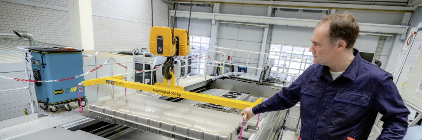 A man in a laboratory with car batteries.