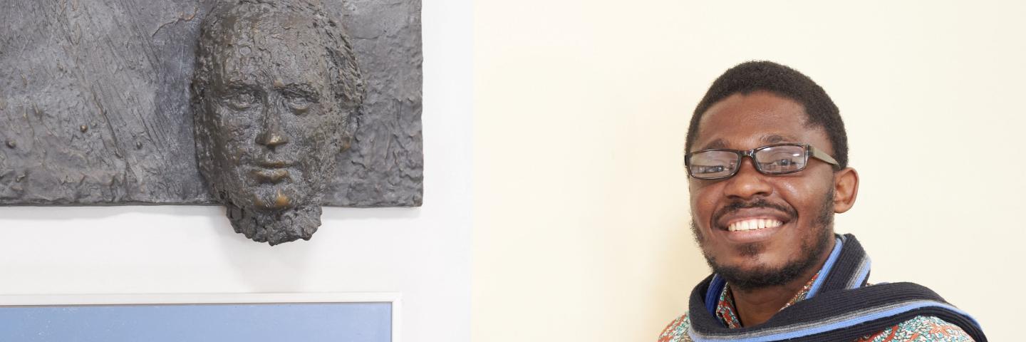  Ein Mann steht neben einem Wandrelief von Friedrich List