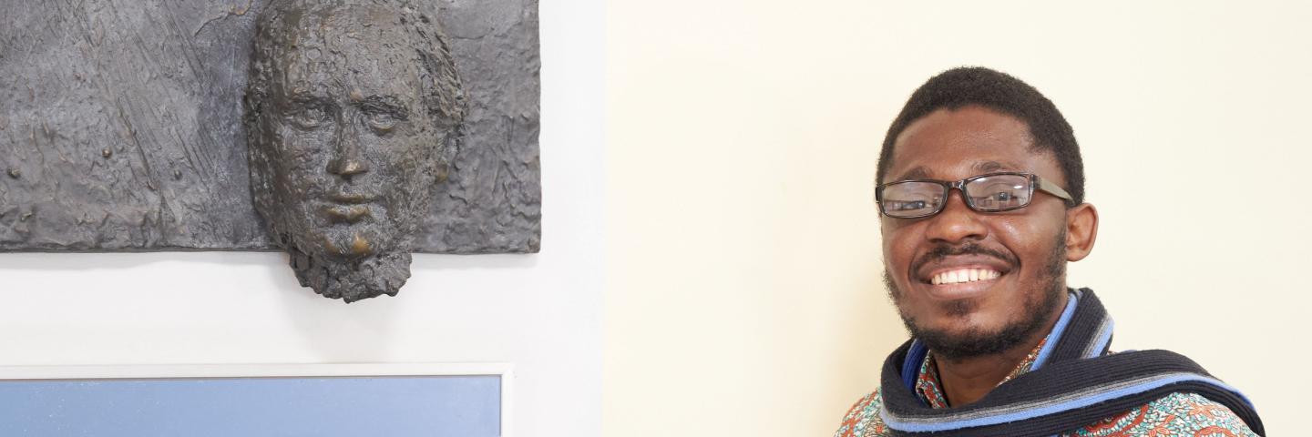  A man stands next to a wall relief by Friedrich List