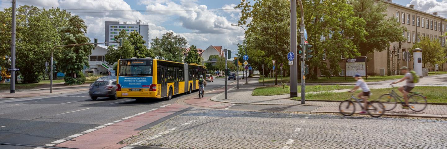 Straßenkreuzung mit Bushaltestelle und Radfahrenden