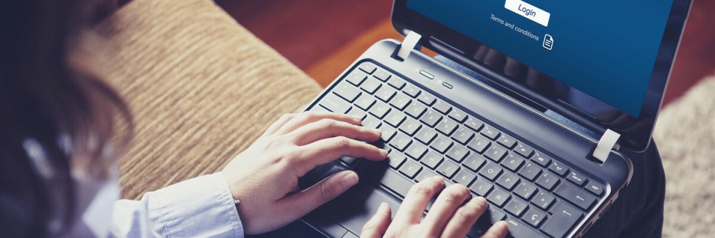 Das Foto zeigt eine Person mit einem Laptop auf dem Schoß.