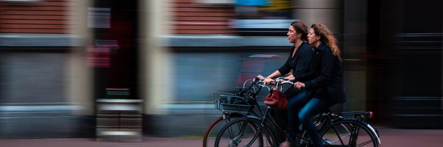 Two women cycling next to each other.