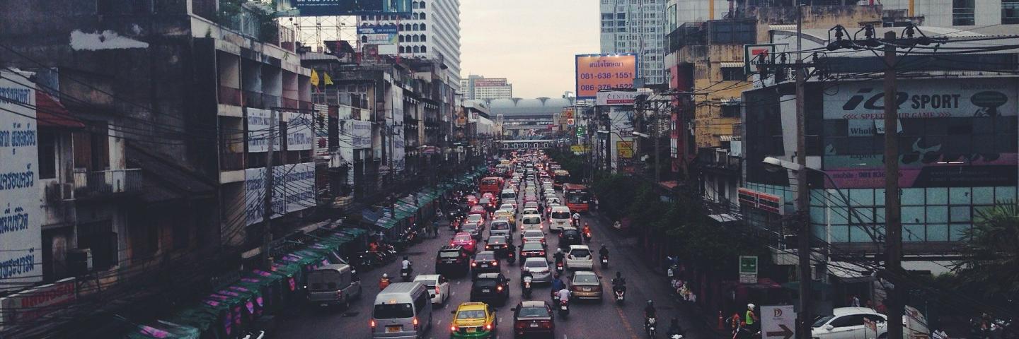 Urban canyons of a big city in India with traffic jams, cars, mopeds.